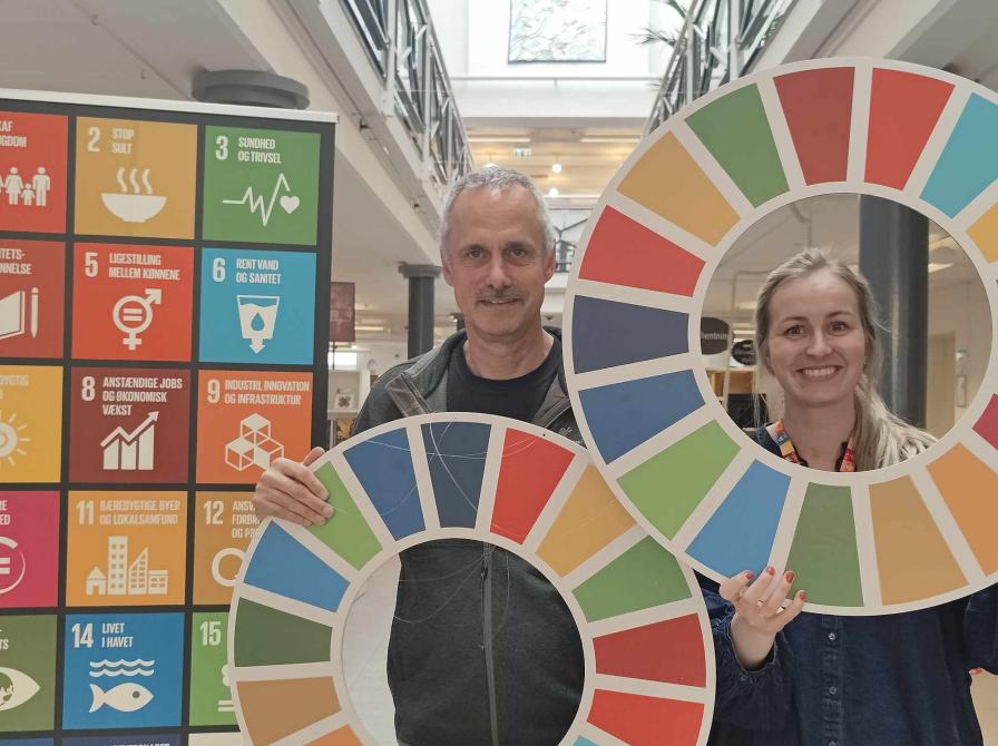 Glade formidlere med Verdensmålenes farverige logoer på Brønderslev Bibliotek 